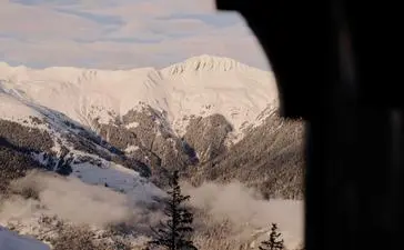 Snowy alpine peaks framed through a window at Aman Le Mélézin, French Alps.