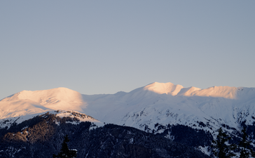 Snow-capped Alpine peaks at Aman Le Mélézin at sunrise, French Alps.