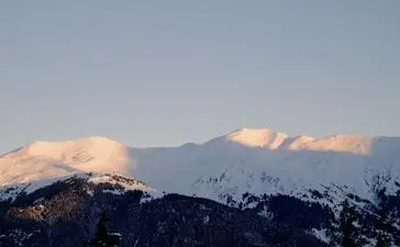 Snow-capped Alpine peaks at Aman Le Mélézin at sunrise, French Alps.