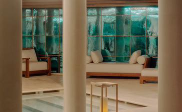 Spa and wellness pool at Aman Le Mélézin viewed through open doorways, with Alpine views beyond.