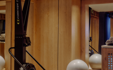 Wellness gym at Aman Le Mélézin with exercise equipment and neutral décor.