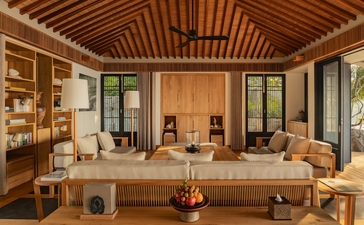 安缦诺怡度假村海景泳池住宅的宽敞客厅,木质天花板和米色家具营造温暖氛围。