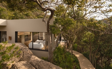 安缦诺怡度假村的海洋泳池住宅水疗屋外观，白色建筑与周围树木相融。