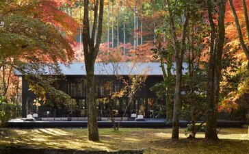Living Pavilion at Aman Kyoto surrounded by autumn foliage and forest trees.