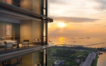 Aman Singapore exterior at dusk, floor-to-ceiling windows overlooking sunset above the city.