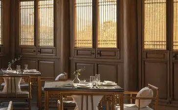 Dining venue at Amandayan with wooden latticed doors and a round table set for service.