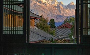 Dining room at Amandayan with mountain views framed by an open window, teal table and chairs in foreground.