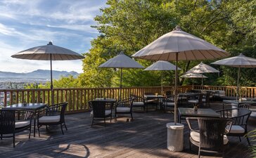 Outdoor dining terrace at Amandayan with umbrellas and seating overlooking the landscape.