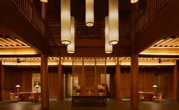 Amandayan lobby with soaring wooden columns and warm lighting illuminating display alcoves.