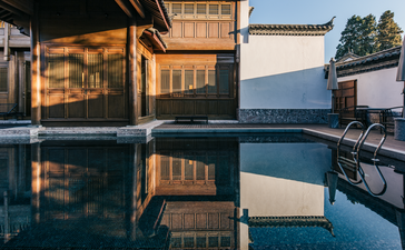 Resort pool at Amandayan reflecting traditional architecture and mountain views at dusk.