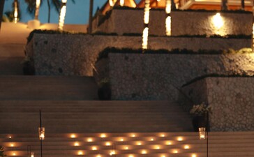 アマンプリのビーチでのバーベキューディナー、照明が灯されたテーブルセットアップ。