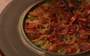 アマンプリのNuraダイニング会場で提供されるメディテラニアン料理、トマトとハーブを使った温かいスープ。