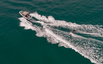 アマンプリ・リゾートでのウェイクボーディング体験。白い波しぶきを上げながら、エメラルドグリーンの海を滑走するウェイクボード。