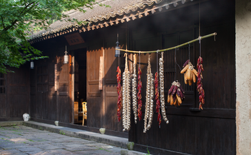 Amanfayun's steam house dining venue with dark timber façade and traditional architecture framed by green foliage.