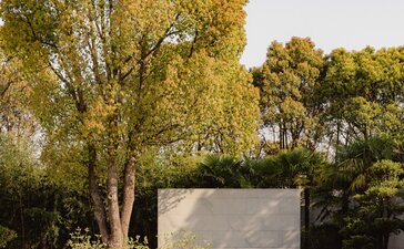 Villa exterior with reflecting pool at Amanyangyun, China, framed by golden trees.