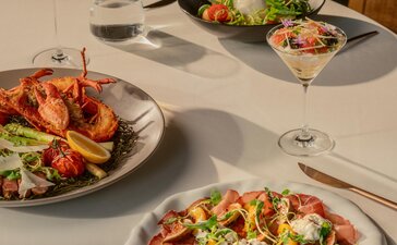 Arva dishes presented on white plates at Amanyangyun's dining venue, featuring vibrant salads and prepared ingredients.