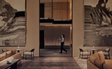 Il Salotto lounge at Aman Rosa Alpina resort, with soaring ceilings and minimalist furnishings.