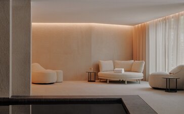 Piscina interna illuminata con vasche in marmo scuro e pareti chiare presso Aman Rosa Alpina.