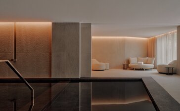 Indoor pool at Aman Rosa Alpina with warm lighting and minimalist design, Italian Alps.