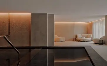 Indoor pool at Aman Rosa Alpina with warm lighting and minimalist design, Italian Alps.