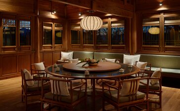 Private dining room at Amandayan restaurant with wooden panelling, round table and traditional chairs.