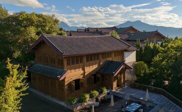 Amandayan's Man Yi Xuan Chinese Restaurant with traditional architecture set against mountain backdrop at dusk.