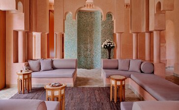 Grand Two-Bedroom Pool Villa lounge at Amanjena resort, Morocco, with terracotta walls and central fountain.