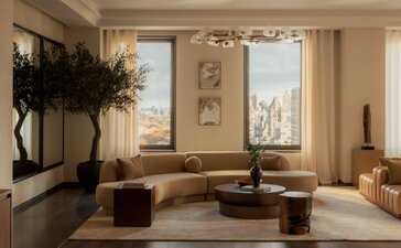 Living area of a three-bedroom penthouse at Aman New York, with floor-to-ceiling windows overlooking the city skyline.