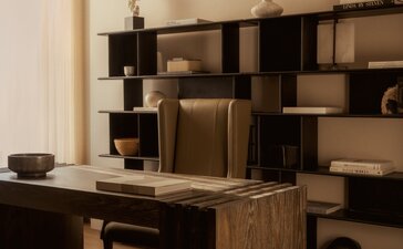 Office workspace at Aman New York with wooden desk, shelving, and minimalist décor.