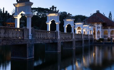 Pont en pierre aux arches bleues illuminées au crépuscule, Amankila, resort en Indonésie.