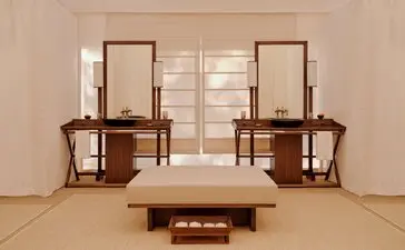 Grand tented pool pavilion at Aman-i-Khas with symmetrical wooden furniture and neutral furnishings.