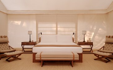 Grand tented pavilion bedroom at Aman-i-Khas with principal bed, seating areas and shuttered windows.
