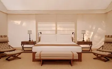 Grand tented pavilion bedroom at Aman-i-Khas with principal bed, seating areas and shuttered windows.