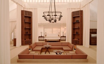 Grand Tented Pool Pavilion at Aman-i-Khas, India, featuring a sunken seating area with wooden furnishings and pendant lighting.