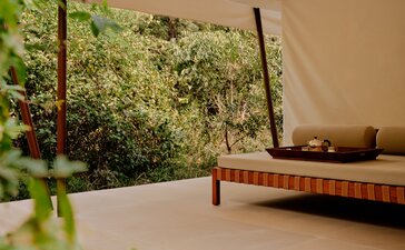 Tented pool pavilion with living wall and wooden daybed at Aman-i-Khas, India.