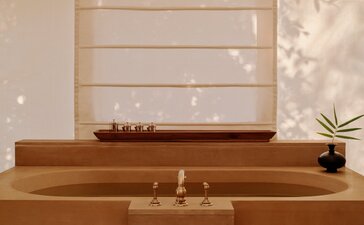 Tented pool pavilion with wooden platform, candles, and spa amenities at Aman-i-Khas, India.