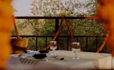 Machan dinner table set with candles and views of the Indian landscape at Aman-i-Khas.