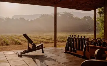 Spa and wellness gym at Aman-i-Khas with exercise equipment overlooking misty plains.
