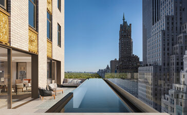 Residential pool at Aman New York with city skyline views and modern architecture.