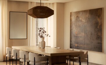 Penthouse dining room at Aman New York with wooden table, pendant lighting, and minimalist artwork.