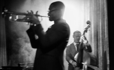 Musician playing trumpet at The Jazz Club in Aman New York, black and white photograph.