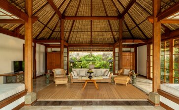 Amandari one-bedroom villa living area with wooden pavilion, thatched roof, and garden views.