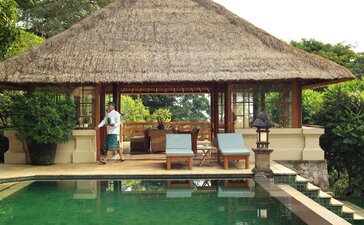 Three-bedroom villa living area at Amandari with thatched pavilion overlooking plunge pool, Indonesia.