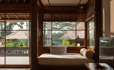 Two-bedroom villa living area with daybed seating and views over Balinese rice paddies at Amandari.