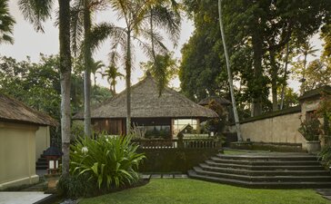 One-bedroom villa garden at Amandari with palm trees and stone steps in Indonesia.