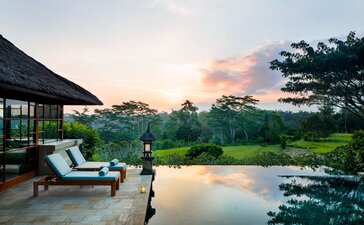 Three-bedroom villa at Amandari with infinity pool overlooking Balinese rice terraces at dusk.
