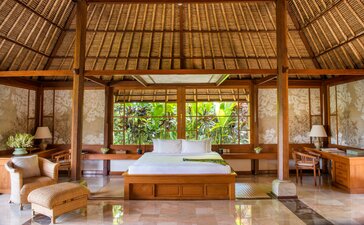 Principal bedroom in an Ayung Pool Villa at Amandari, Indonesia, with wooden furnishings and garden views.