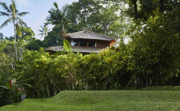 Duplex pavilion exterior at Amandari set amongst tropical gardens and verdant lawns in Indonesia.