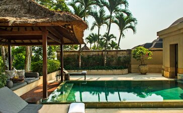 Garden pool pavilion at Amanjiwo, Indonesia, with covered seating area overlooking emerald plunge pool.