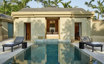 Menoreh Pool Pavilion at Amanjiwo, with reflecting pool and symmetrical stone structure in Indonesia.